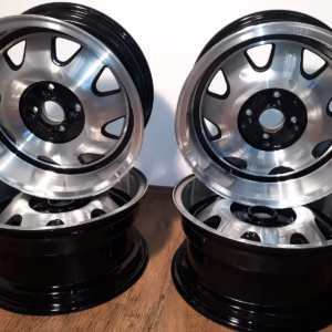 Vier Felgen Ats Cup Felgen 7x15 Et.20 7056, aufgearbeitet für Golf 1 und Golf 2, haben eine polierte silberne Oberfläche mit schwarzen Akzenten. Zwei stehen aufrecht und zwei liegen flach auf einem Holzbrett, um ihren klassischen Stil zu präsentieren.