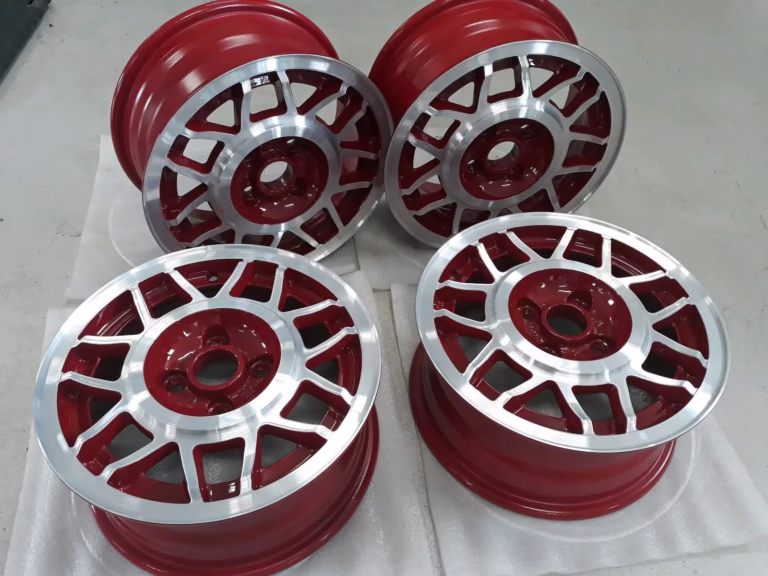 Vier Avus Snouflake Felgen Paprika Rot für die Modelle Golf 1 und Scirocco mit silberner Oberfläche sind auf einer weißen Fläche ausgestellt.