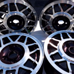 Vier Avus Snowflake Alufelgen Dark Burgundy LC3U für Golf 1 Scirocco im Mehrspeichendesign sind aufrecht und flach auf einer weißen, das Sonnenlicht reflektierenden Fläche angeordnet.