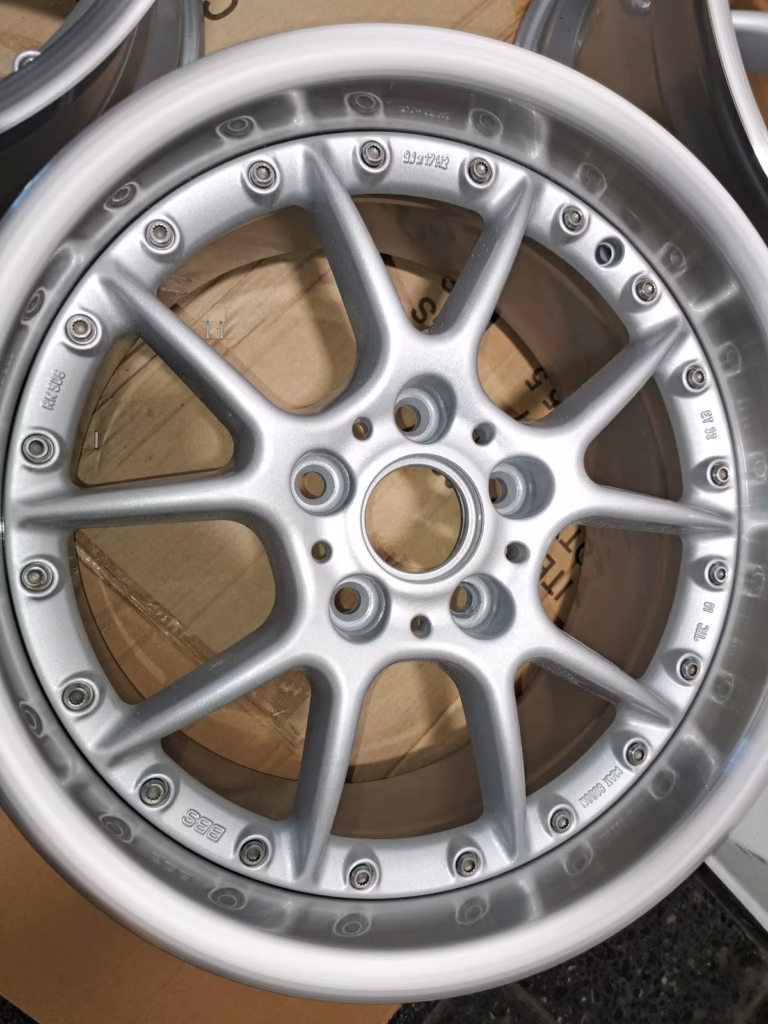 Nahaufnahme einer Bbs Bmw Rk500 Rk560 8x17 9x17 Leichtmetallfelge mit silbernem Vielspeichendesign, dargestellt auf einer Kartonoberfläche.