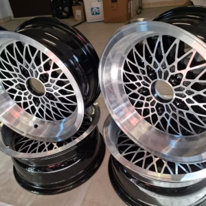 Vier Bmw Mim Felgen 7x15 Et 7 Kba 41940 E12-E3-E9-E28 in Schwarz und Silber mit Netzmuster sind paarweise auf einem hellen Boden gestapelt und tragen jeweils die authentische Kennzeichnung Kba 41940.